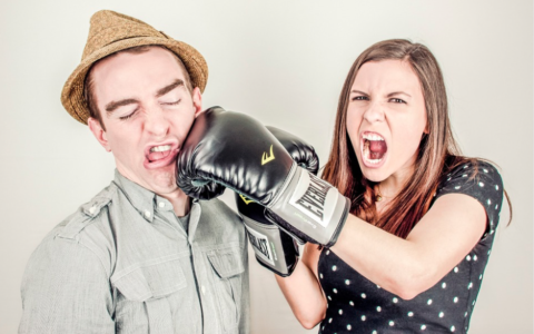 woman punching a man int he face with a boxing glove to illustrate small businesses punching above their weight