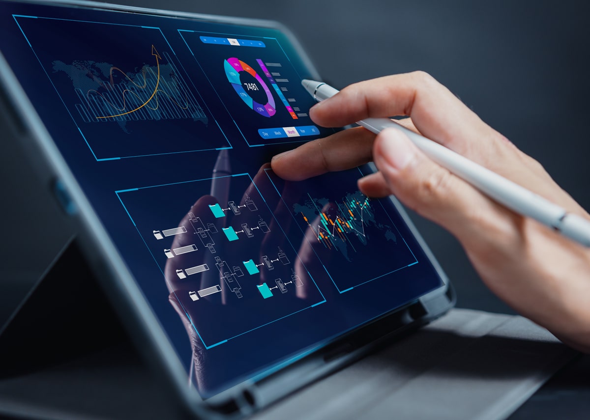 Close-up view of a professional using a stylus to interact with sophisticated data analytics on a tablet screen, showcasing graphs and marketing metrics.